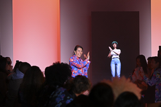 14일(현지시간) 미국 뉴욕에서 열린 '뉴욕 패션 위크'에서 박윤희 디자이너가런웨이에 올라 AI아티스트 틸다와 함께 관객들에게 인사하고 있다. <LG그룹 제공>